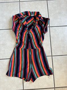 This 1970's striped jumpsuit has a zipper front and cap sleeves with a booty shorts look.  It is missing a belt.  It is an XS but please refer to the size measurements below for an accurate fit.  The hem on the shorts is falling out as shown in pictures. It is in decent condition other than that. I think the fabric is a poly knit but not 100% sure. V-neck(collar to zipper)-6 inches Chest-32 inches Waist-24 inches no pull/26inches with pull Hips-36 Rise-12 inches Inseam-2 inches Sleeve-1 inch Collar point-4 inches Zipper length-13 inches Waist to hem-11 inches To see more of our authentic 1970's vintage clothing inventory please visit our store at ChoiceRecycling.  We add new items every week. Retro Multicolor Jumpsuits And Rompers For Summer, Striped Short Sleeve Jumpsuits And Rompers For Beach, Retro Multicolor Jumpsuits And Rompers For Spring, Striped Short Sleeve Jumpsuits And Rompers For Summer, Fitted Jumpsuits And Rompers With Vertical Stripes, Casual Summer Jumpsuits And Rompers With Vertical Stripes, Casual Striped Fitted Jumpsuits And Rompers, Casual Fitted Striped Jumpsuits And Rompers, Fitted Multicolor Short Sleeve Jumpsuits And Rompers