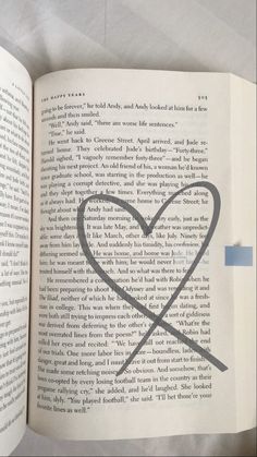 an open book with a heart drawn on the page and two lines in the middle