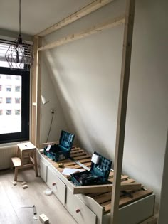 a bed frame made out of wooden pallets in a room with an open window