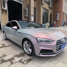 a silver car parked in front of a building