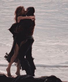 two people embracing each other on the beach