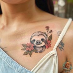 a woman with a slotty tattoo on her shoulder and chest, holding onto a flower