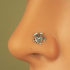 a close up view of the side of a woman's nose with a turtle on it