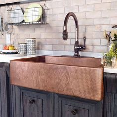 a kitchen sink sitting under a faucet on top of a wooden cabinet next to a counter