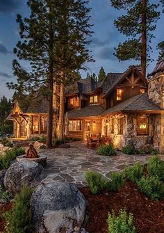 a large stone house sitting on top of a lush green hillside next to the ocean