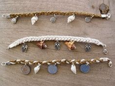 several different types of bracelets with shells on them hanging from strings and roped together