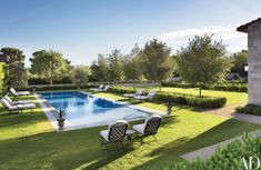 an outdoor swimming pool surrounded by lawn chairs