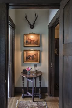 two deer heads mounted on the wall above a table