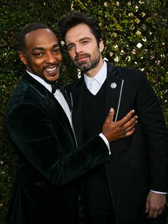 two men in tuxedos are hugging each other