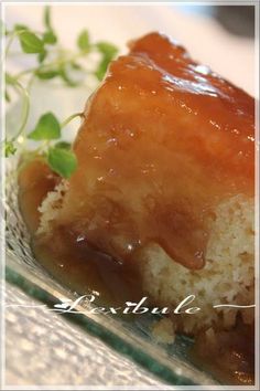 a piece of cake covered in caramel sauce on top of a plate with green sprigs