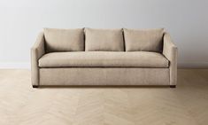 a couch sitting on top of a hard wood floor next to a white wall and wooden floors