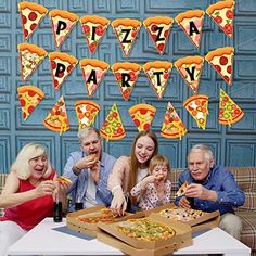 a group of people sitting around a table eating pizza