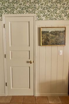 an open door with a painting on the wall behind it