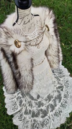 a mannequin wearing a white lace dress and fur collar