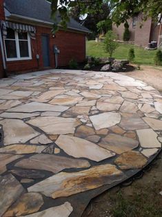 a stone patio in front of a house