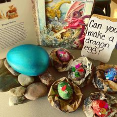 an open book and some rocks on a table with other items in front of it