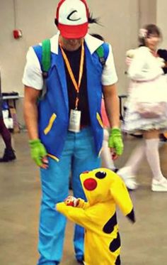 a man in costume standing next to a child dressed up as pikachu and pokemon