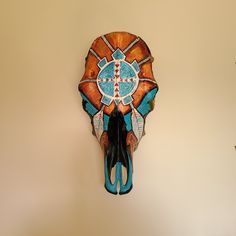 an animal's skull mounted on the wall with blue and orange decorations around it