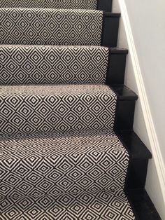 black and white carpeted stairs leading up to the second floor