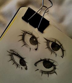 a clipboard with an eye drawn on it next to a pen and paper clip