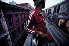 a man standing on top of a wooden deck next to graffiti covered walls and buildings