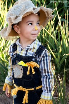 a little boy wearing a hat and overalls