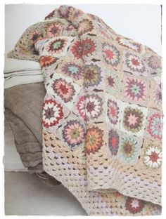 a crocheted blanket is shown on the bed