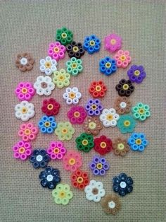 the beads are all different colors and sizes on the table top, including one flower