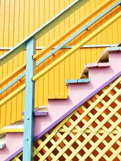 an orange and blue stair case next to a yellow wall