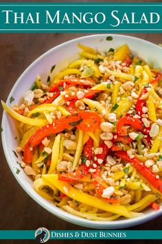 the cover of thai mango salad is shown in a white bowl with silver spoons