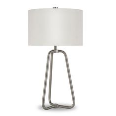 a lamp with a white shade on the base and a silver metal frame around it