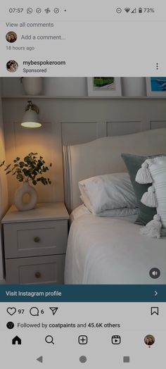 a bed with white sheets and pillows on top of it next to a night stand