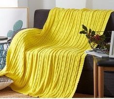 a living room with a yellow blanket on the couch