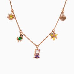 a gold necklace with charms on it, including an initial charm and two small stars