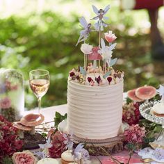 a wedding cake with flowers and candles on the top is surrounded by other desserts