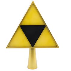 a yellow and black triangle shaped object on a stand