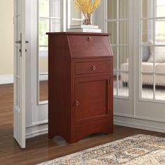 a small wooden cabinet sitting in front of a window next to a carpeted floor