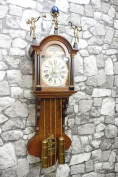 an old clock on the wall with bells and pendulums attached to it's sides