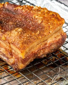 a piece of meat sitting on top of a metal grill grate covered in grease