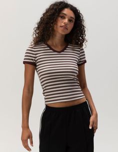 Full Tilt V-Neck Baby Tee. Ribbed Knit Construction. Allover Stripe Print. V-Neckline. Short Sleeve. Shrunken Fit. 57% Cotton, 38% Polyester, 5% Spandex. Machine Wash. Imported. Model Is Wearing A Size Small. Model Measurements:height: 5'7" Bust: 32cwaist: 24"hips: 35" Stretch V-neck Top With Ribbed Neckline, Striped Stretch V-neck Top, Ribbed V-neck Elastane Top, Ribbed Cotton V-neck T-shirt, Sporty Striped V-neck Top, Ribbed Elastane V-neck Top, Ribbed V-neck Top In Elastane, Sporty V-neck Top, Sporty Fitted Top With Ribbed Neckline