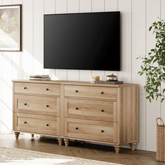 a living room scene with focus on the dresser and flat screen tv mounted to the wall