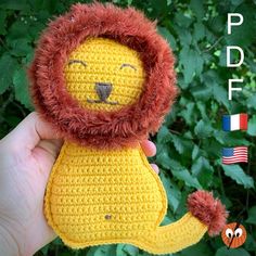 a crocheted lion stuffed animal is held up