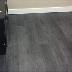 a cat is sitting on the floor in front of a glass table with drawers underneath it