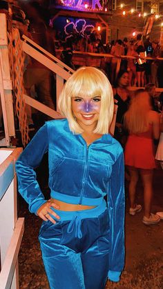 a woman with blonde hair and blue outfit posing for the camera