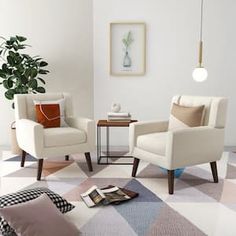 a living room with two white chairs and a coffee table on the floor in front of a potted plant