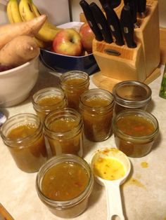 several jars filled with food sitting on top of a counter next to bowls and spoons