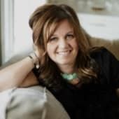 a woman sitting on top of a couch next to a window