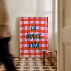 a poster that says la dolce vita on it in front of a checkered floor