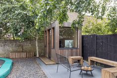 a backyard with a trampoline, table and bench next to the fenced in area