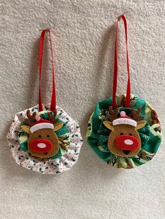 two christmas ornaments hanging on the wall next to each other, one with a reindeer head